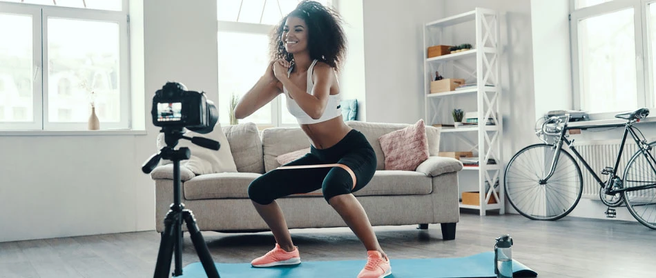 A person performs exercise routines in front of a camera.